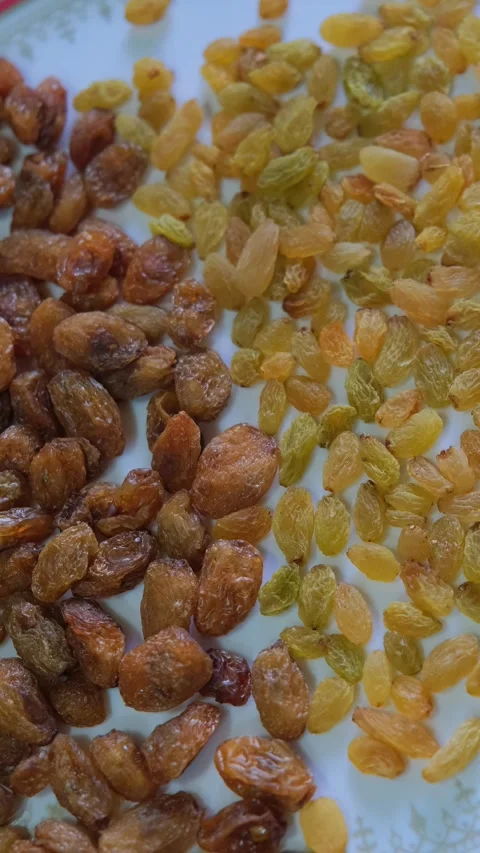 High angle shot of two varieties of raisins, brown munakka and golden kishmish Vidéo 333202748