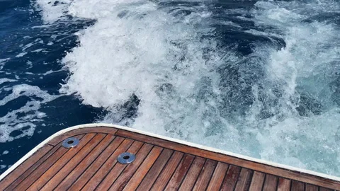 High angle shot on wake foam from riding speed boat along the water, wood stern Stock-Footage 318647582