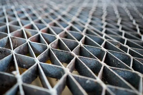 High-angle shot of weathered concrete lattice floor featuring repeating trian Stock Photos