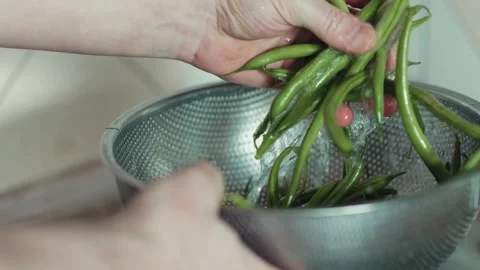 High angle shot of wet green beans inside a stainless steel strainer bowl Stock Footage 343555646