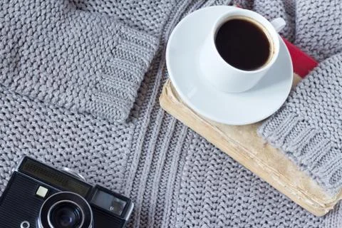 High-angle shot of a white ceramic cup with white coffee, book and an old cam Foto stock