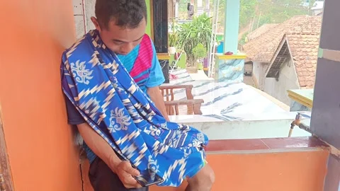 A high-angle, slice-of-life shot of a man completely absorbed by his phone scree Stock Footage 315308525
