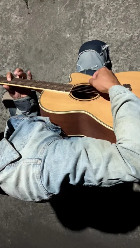 High Angle Slow Motion of Musician Playing Acoustic Guitar Lap Vertical Stockbeeldmateriaal 337228499