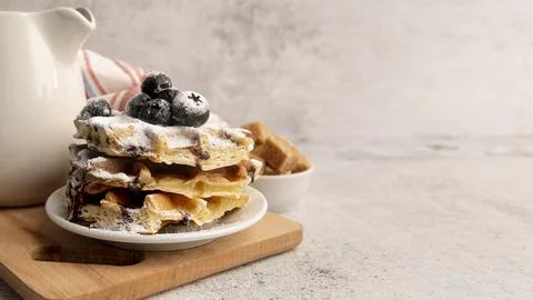 High angle stacked waffles plate with powdered sugar chocolate sauce Stock Photos
