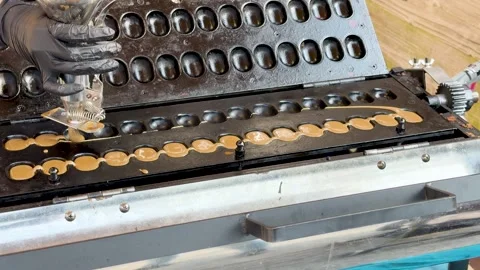 A high-angle static shot capturing the process of pouring mini pancake batt.. Stock Footage 333081897