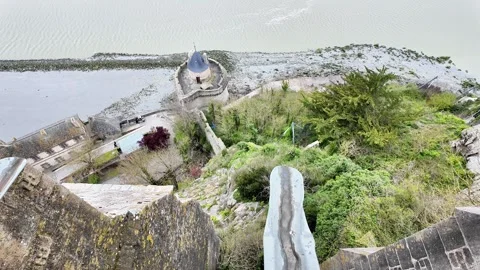 High angle static shot overlooking the tidal bay and access bridge of Mont Saint Vídeos de archivo 332724108