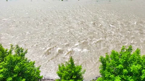 High angle steady shot of a muddy river flowing rapidly after heavy rain Stock Footage 342238559