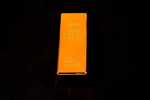 A high angle studio shot featuring a single large fine gold bullion bar cen.. Stock Photos