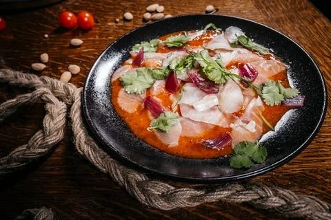 High-angle studio shot of an intricately arranged fish sashimi on a round bla 스톡 사진