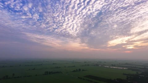 High Angle Sunrise Landscape of Vast Green Farmland with Ripple Cloud Sky Stock Footage 344793620