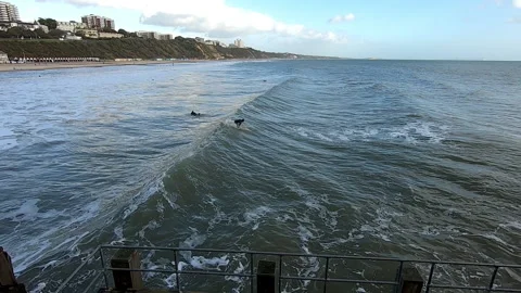 High angle of surfers catching waves in winter Bournemouth Beach, 4k, United Stock Footage 200886504