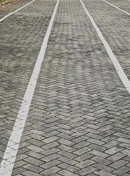 High Angle Texture of Herringbone Pavement with Parallel White Traffic Lines Stock Photos
