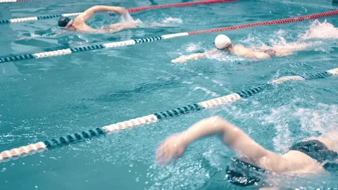 High angle three swimmers having competition in swimming pool tracking shot Video stock 94442161