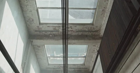 High angle tilt following elevator cables, looking down an industrial freight Stock Footage 138608283