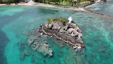 High angle top down drone view over a small rocky islet and shallow transparent Stock Footage 337160527