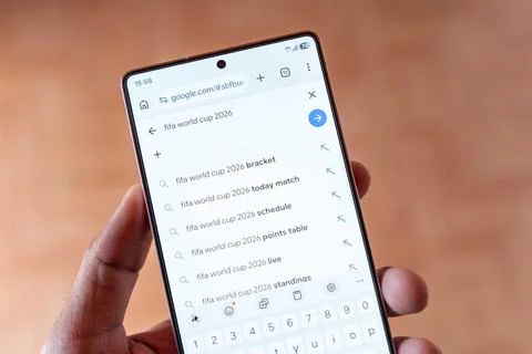 High Angle Top View of Smartphone Held in Hand Showing Google Search. Stock Photos