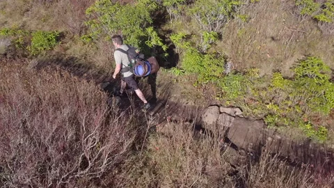 High angle tracking shot of lone backpacker hiking Stock Footage 142235744