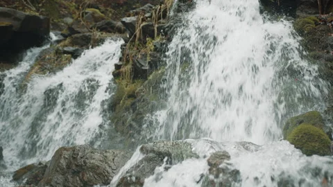 High angle of turbulent waters flowing down, striking rocky slope in a forest Stock Footage 256795780