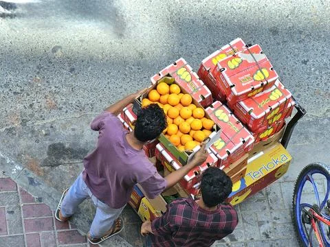 From a high angle, two men push a cart Stock Photos