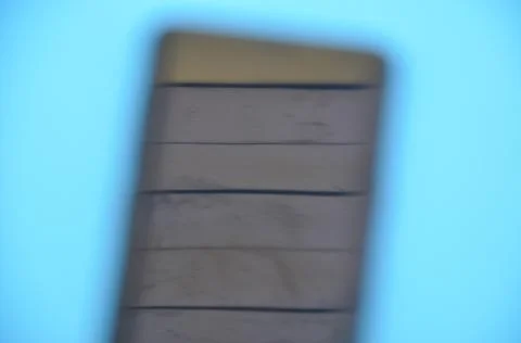 High angle of unique blurred abstract photo of a phone over blue background. Stock Photos