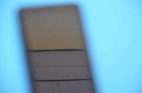 High angle of unique blurred abstract photo of a phone over blue background. Stock Photos