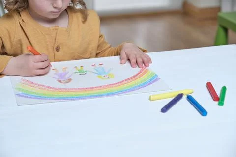 High angle of unrecognizable kid drawing picture of mothers and child under r Stock Photos