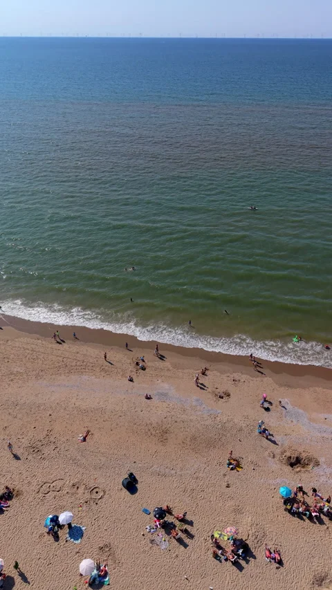 High angle vertical aerial drone video clip of sandy beach with beachgoers Stock Footage 342634780