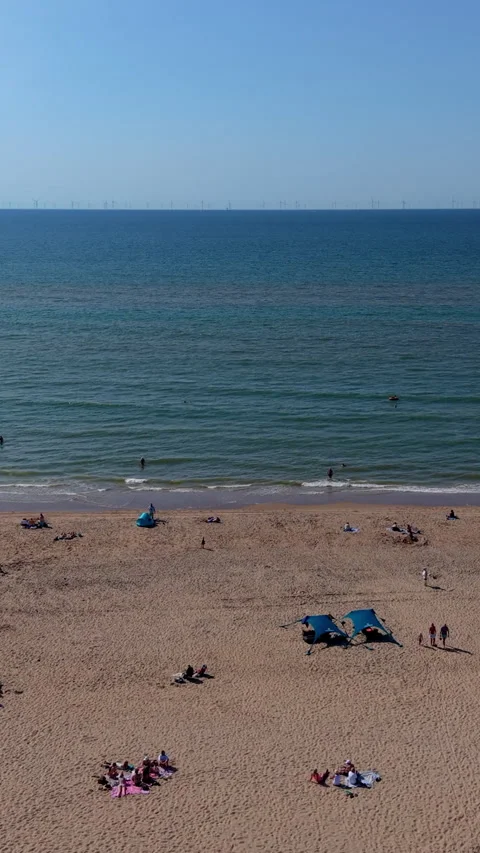 High angle vertical aerial drone video clip of sandy beach, beachgoers sun Видео 343140772