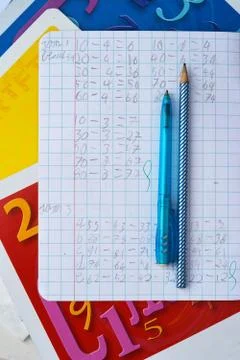 High angle vertical shot of open notebook with Math exercises, blue pen, pencil Stock Photos
