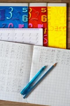 High angle vertical shot of open notebook with Math exercises, blue pen, pencil Stock Photos