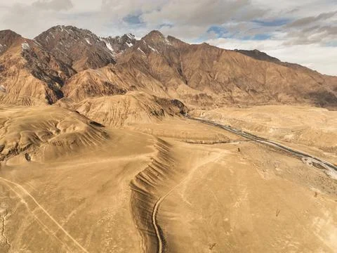 High angle view of arid mountain valley and winding tracks Stock Photos