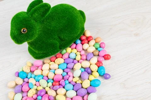 High angle view of artificial moss bunny with colorful candy easter eggs on 스톡 사진
