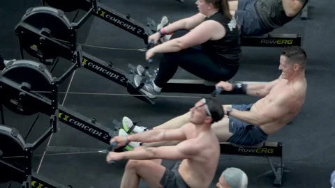 High Angle View of Athletes Training on Rowing Machines at Fitness Competition Vídeos de archivo 342290389