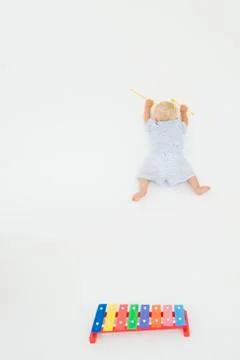 High angle view of a baby boy fallen near a xylophone Stock Photos