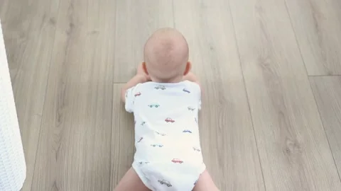 High angle view baby crawling wooden floor, toddler kid child lying on floor Stock Footage 201628098