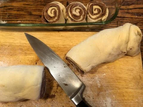 High angle view of bakery counter and knife cutting cinnamon rolls Stock Photos