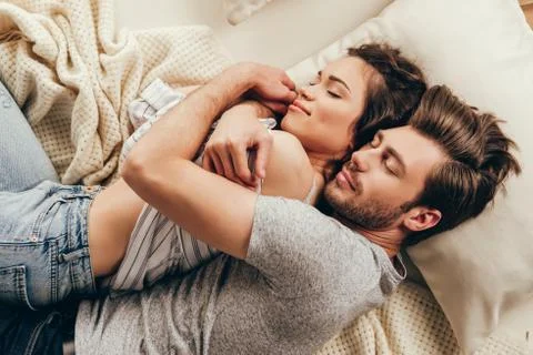 High angle view of beautiful happy young couple hugging while sleeping on bed Stock Photos