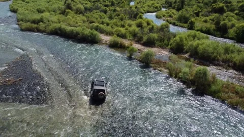 High angle view of black 4x4 off-road vehicle driving through mountain river Stock Footage 335081429