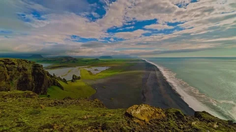 High angle view black sand beach and green coastal cliffs under a blue sky Stock Footage 339781545