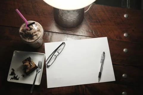 High angle view of blank paper with equipment and dessert beverage on wooden Foto stock
