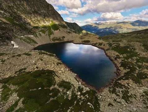 High angle view of a blue alpine lake surrounded by rocky mountains Stock Photos