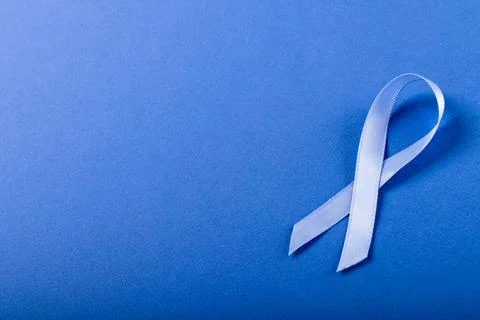 High angle view of blue stomach cancer awareness ribbon isolated against blue Stock Photos