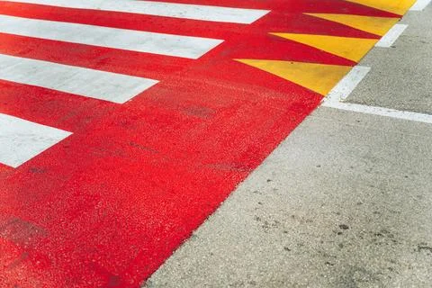 High-angle view of bright red, yellow, and white geometric pedestrian zebra.. Stock Photos