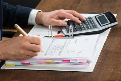 High angle view of businessman using calculator while checking invoice at des Stock Photos