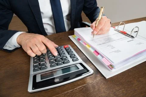 High angle view of businessman using calculator while checking invoice at des Stock Photos