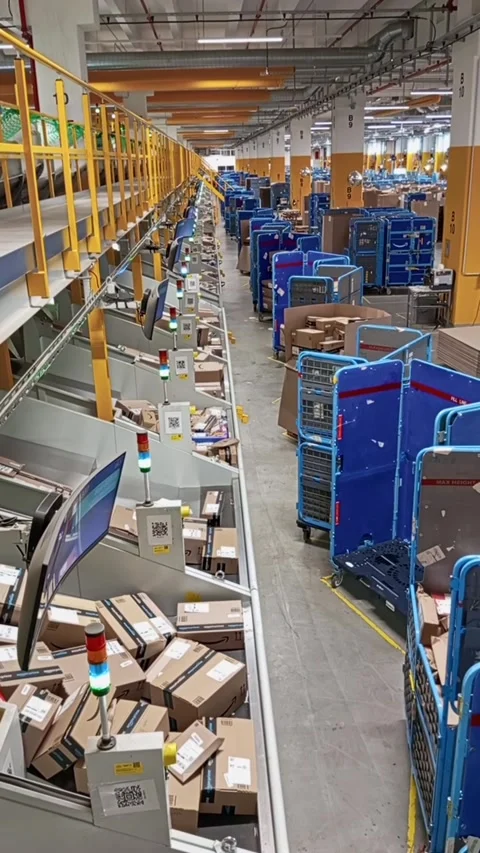 High angle view of a busy Amazon fulfillment center sorting line with stacked Stock Footage 333488594