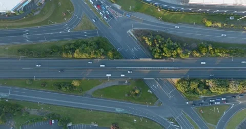 High-angle view of busy highway intersections, parking lots, and buildings. MT Stock-Footage 296037344