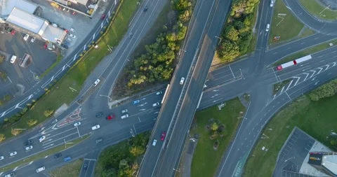 High-angle view of busy highway intersections, parking lots, and buildings. MT Stock-Footage 296037617