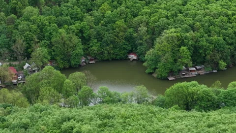A high angle view captures small wooden houses and cabins situated along the Stock Footage 336382374