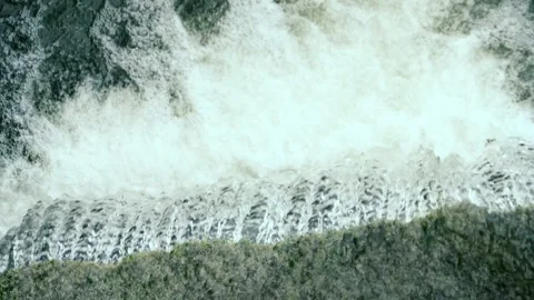 High-angle view capturing the powerful, cascading flow of a small waterfall Vídeos de archivo 335043422